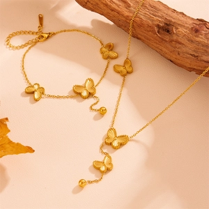 Detailed view of golden butterfly necklace and bracelet set with etched textures