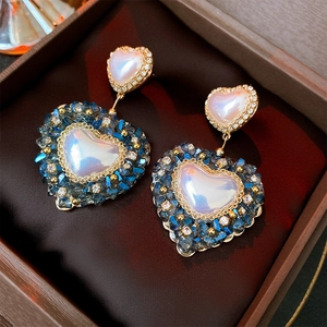 Baroque style heart earrings with pink crystals and blue gems in a vintage jewelry box