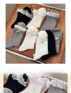 Detail showing lace trim, delicate ribbon bows, and bell charms on cotton socks