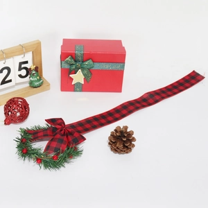 Detail of Christmas ribbon wreath with red berries and plaid bow in festive holiday setting