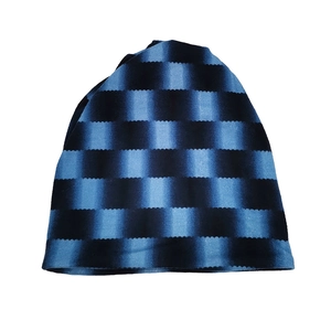 Detail of blue and black horizontal striped knit beanie with unique zigzag edge pattern