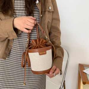 Vintage brown leather and beige canvas bucket bag with adjustable shoulder strap