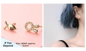 Detail view of asymmetric gold fish and crystal rabbit earrings, width 0.6cm
