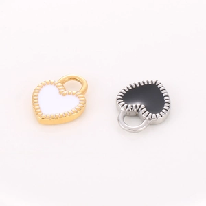 Detail of heart-shaped lace pendants in gold with white enamel and silver with black enamel