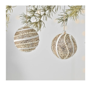 Detailed view of two gold foam Christmas balls with white bead stripes and sequins