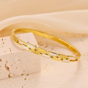 Macro detail of golden titanium steel bracelet featuring white LOVE letter engraving