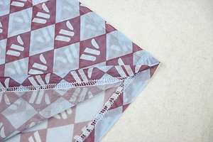 Detail of sheer mesh fabric with blue and maroon argyle pattern and fine stitching