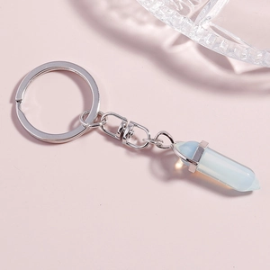 Macro detail of hexagonal opal crystal bullet pendant with silver metal keyring