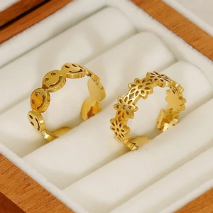 Gros plan de bagues ajustables en acier titane doré 18K avec smileys et fleurs