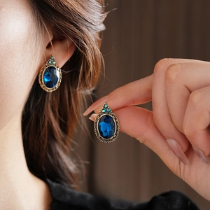Boucles d'oreilles vintage style palais avec gemmes bleues ovales et détails en bronze