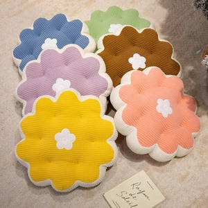 Colorful floral plush cushions with corduroy texture arranged on a cozy home rug