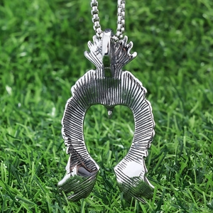 Minimalist flying eagle stainless steel pendant for men on a green natural background