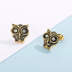 Vue macro des boucles d'oreilles hibou dorées avec accents noirs et yeux en cristal