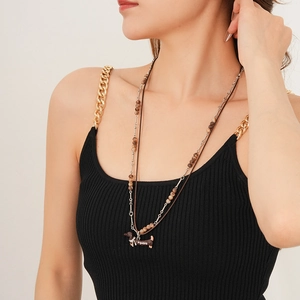 Detail shot of a double-layered necklace featuring a brown dachshund pendant with Happy engraving