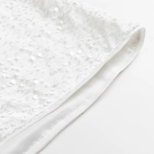 Détail macro des paillettes blanches élégantes et coutures fines sur la robe