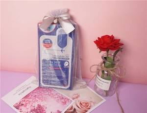 Detail of silver organza gift bag with champagne silk bow and pearl decoration for masks