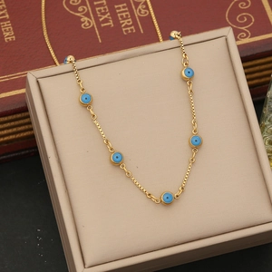 Detailed close-up of a gold double-layer chain necklace with blue evil eye beads