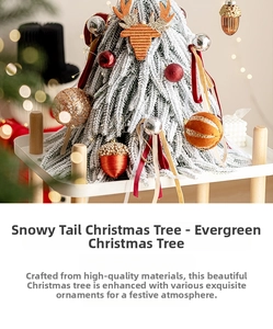 Détail d'un sapin artificiel enneigé avec boules rouges et décorations festives de cerf