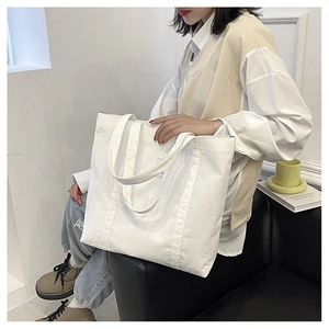 Detail of a large capacity white corduroy shoulder bag showing fabric texture and style