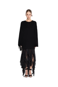 Detail of black knit sweater featuring irregular lace stitching and chiffon skirt hem