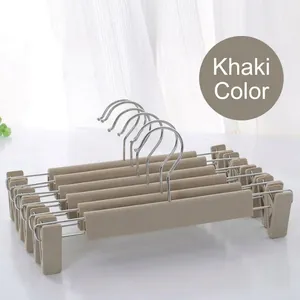 Detail of khaki non-slip pant hangers with adjustable clips and durable metal hooks