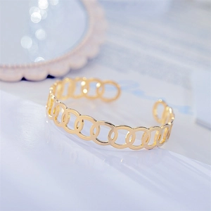 Close-up view of a gold titanium steel cuff bracelet with interlocking circle design