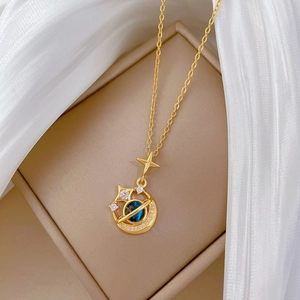 Detail of gold star and moon pendant with blue stone and crystals in a gift box