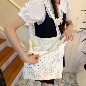 Close-up of white polka dot canvas tote bag showing organized multi-compartment interior