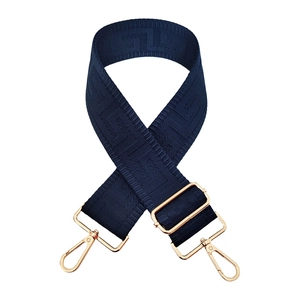 Macro detail of dark blue jacquard wide shoulder strap with golden metal swivel hooks