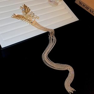 Détail d'une pince à cheveux papillon dorée avec de longues chaînes et des strass