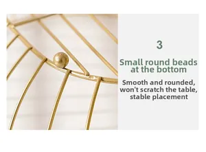 Detail of golden iron fruit basket featuring smooth spherical support feet for stability