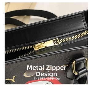 Close-up of golden zipper and D-ring hardware on black textured leather tote bag