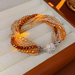 Détail macro du bracelet multicouche en cristal ambre avec fermoir magnétique en strass