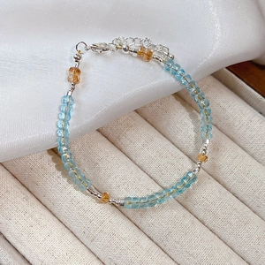 Macro view of crystal beaded bracelet with blue and amber multifaceted stones and silver clasp
