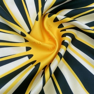 Detailed close-up showing the smooth silk texture and radial geometric pattern of the scarf