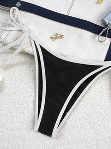 Detail of black bikini bottom with contrast white piping and adjustable side ties
