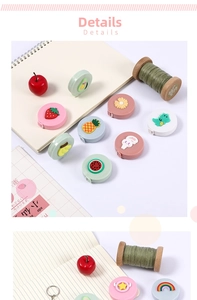 Close-up of portable cartoon mini tape measures on a white desk with sewing accessories