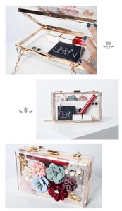 Detail view of floral acrylic clutch featuring 3D fabric flowers and gold chain strap