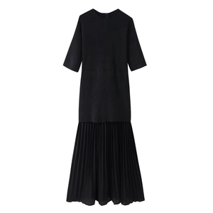 Detail of minimalist black short sleeve dress with elegant accordion pleated hem design