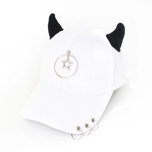 Detail of white baseball cap with black demon horns and silver metal star charm pendant