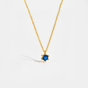 Detailed close-up of a blue zircon pendant with a classic six-prong gold setting