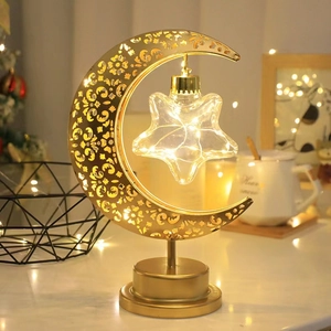 Detail of LED light string inside glass star suspended on golden moon frame lamp