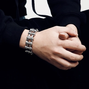 Gros plan d'un bracelet gourmette punk en acier avec tête de mort sur poignet masculin