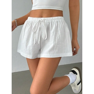 Detailed macro view of white cotton-linen shorts showing elastic drawstring waist and texture