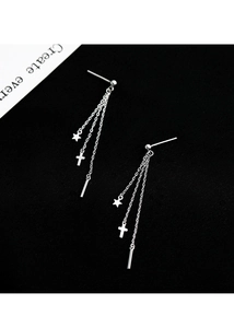 Detailed close-up of silver chain earrings with cross and star charms on black background