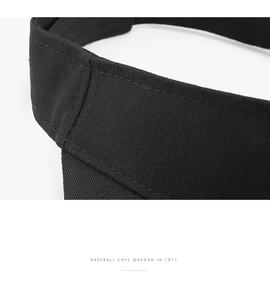Close-up of double-stitched seam and black cotton twill fabric on a sun visor cap