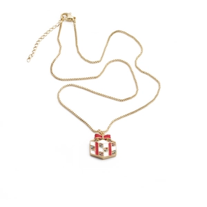 Close-up of gold gift box pendant necklace with red bow and colorful zircon stones