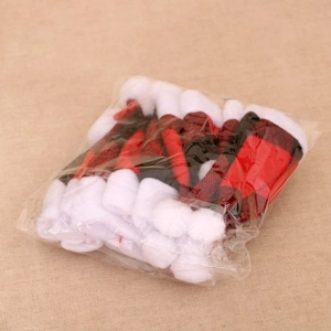 Detailed view of mini red and black plaid Christmas hat cutlery holders in bulk packaging