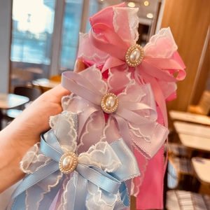 Three elegant ribbon bows with pearls for girls in pink, purple, and blue colors