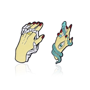 Creative snake and skull hand enamel pins with vibrant colors on a white background